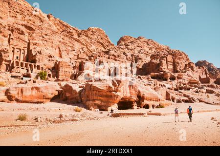 Touristenwanderung durch Höhlen von Gräbern in der antiken Stadt Petra, Jordanien. Es ist bekannt als das Loculi. Petra hat zu seiner Ernennung zum UNESCO-Weltkulturerbe S geführt Stockfoto