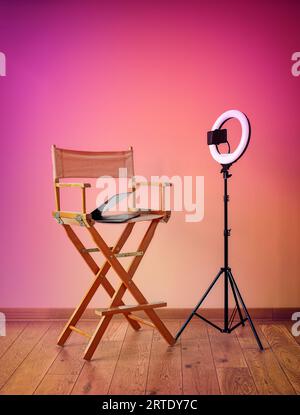 Director's Chair, Ringlichter, Digitalkamera mit Laptop und Hüte auf buntem Hintergrund mit Aufnahmegerät Stockfoto