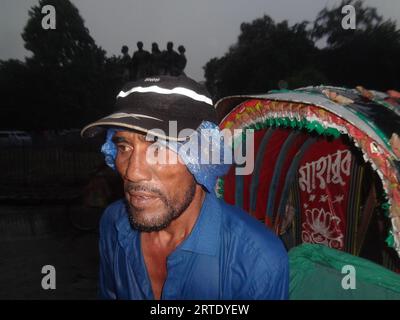 Dhaka, Bangladesch. September 2023. Ein Rikscha-Abzieher bedeckte seinen Kopf mit einer Plastikfolie, um Regen in Dhaka zu vermeiden. (Bild: © MD Mehedi Hasan/ZUMA Press Wire) NUR REDAKTIONELLE VERWENDUNG! Nicht für kommerzielle ZWECKE! Stockfoto