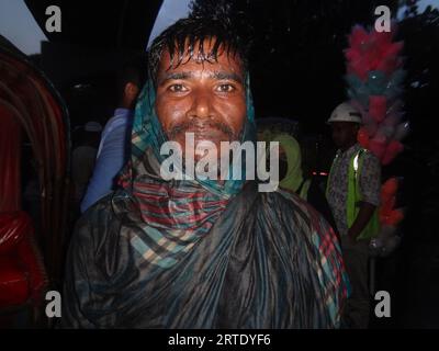 Dhaka, Bangladesch. September 2023. Ein Rikscha-Abzieher reagiert auf die Kamera, während er seinen Körper mit einem Tuch bedeckt, um Regen in Dhaka zu vermeiden. (Bild: © MD Mehedi Hasan/ZUMA Press Wire) NUR REDAKTIONELLE VERWENDUNG! Nicht für kommerzielle ZWECKE! Stockfoto