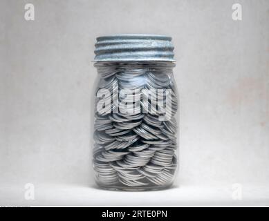 Glas mit Münzen Stockfoto