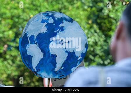 Den Haag, Südholland, Niederlande. September 2023. Ein Aktivist hält während der gewaltfreien Sitzdemonstration auf dem Utrechtsebaan ein großes Plakat des Planeten Erde. Die Extinction Rebellion organisierte heute Nachmittag eine Blockade auf der Autobahn A12 in den Haag, trotz eines Verbots der Gemeinde. Der sogenannte˜Froschstrahl des deutschen Wasserkanons wurde verwendet, um die Demonstranten während ihres Sitzes zu zerstreuen; dies hatte nur wenig Wirkung, da die meisten auf ein solches Ereignis vorbereitet waren. Nach Angaben des Organisators Extinction Rebellion nahmen etwa 25.000 Menschen an den Protesten Teil. (Bild: © Stockfoto