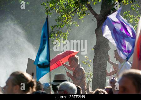 Den Haag, Südholland, Niederlande. September 2023. Die Klimaaktivisten der Extinction Rebellion kommen während der gewaltfreien Demonstration auf dem Utrechtsebaan unter Wasserkanon. Die Extinction Rebellion organisierte heute Nachmittag eine Blockade auf der Autobahn A12 in den Haag, trotz eines Verbots der Gemeinde. Der sogenannte˜Froschstrahl des deutschen Wasserkanons wurde verwendet, um die Demonstranten während ihres Sitzes zu zerstreuen; dies hatte nur wenig Wirkung, da die meisten auf ein solches Ereignis vorbereitet waren. Nach Angaben des Organisators Extinction Rebellion nahmen etwa 25.000 Menschen an den Protesten Teil. (Credi Stockfoto