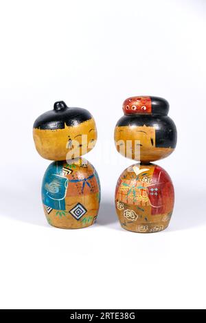 Vintage japanisch bemalte hölzerne Kokeshi Volkspuppengruppe isoliert vor einem weißen Studiohintergrund Stockfoto