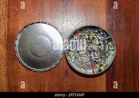 Nahansicht vieler Nähstifte mit farbigen Köpfen in Einer Metallbox Stockfoto