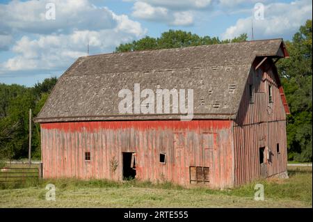 Verlassene Scheune mit verwitterter Fassade und verblasster roter Farbe, in der Nähe von Dunbar, Nebraska, USA; Dunbar, Nebraska, Vereinigte Staaten von Amerika Stockfoto