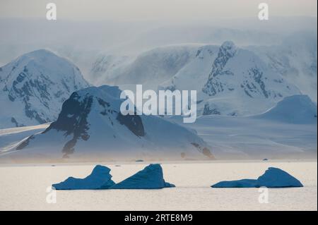 Westseite der Antarktischen Halbinsel mit schneebedeckten Bergen und Eisbergen im südlichen Ozean; Antarktische Halbinsel, Antarktis Stockfoto