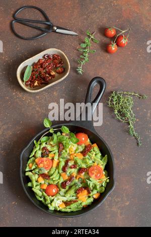 Grüne Spätzle mit Ricotta-Creme und Tomaten Stockfoto