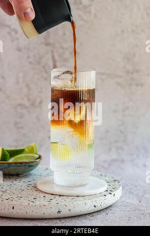 Tonic auf Eis mit Espresso-Belag und Limetten Stockfoto