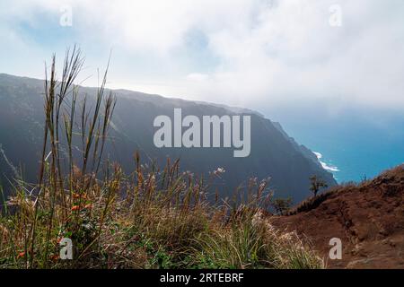 Malerischer Blick auf die Bergklippen der Napali Coast entlang des Kalalau Trail auf der hawaiianischen Insel Kauai mit Blick auf die nebeligen Wolken über... Stockfoto