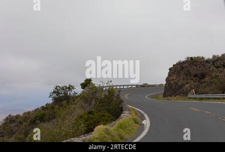 Gewundene Bergstraße mit grauem, bewölktem Himmel entlang der malerischen Fahrt von Kihei nach Haleakala und zurück; Maui, Hawaii, Vereinigte Staaten von Amerika Stockfoto