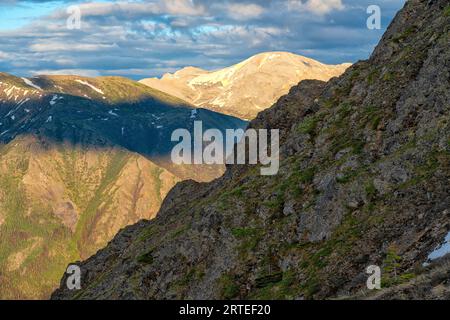 Nahaufnahme der Berggipfel, die durch das warme Licht des Sonnenuntergangs mit Farbe gemalt werden; Carcross, Yukon Territory, Kanada Stockfoto