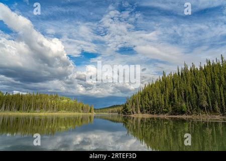 Ruhige Bedingungen auf dem Yukon River schaffen die perfekte Umgebung für eine Reflexion an einem schönen Sommerabend im Yukon Stockfoto