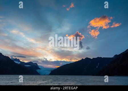 Sonnenuntergang über dem Holgate-Gletscher und den Kenai-Bergen, mit glühenden Wolken an einem Sommertag in Holgate Arm, Aialik Bay, Kenai Fjords National Park, Al... Stockfoto