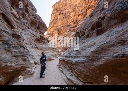 Junge Beduinen in einem engen felsigen Canyon in der Wüste Wadi Rum, Jordanien Stockfoto