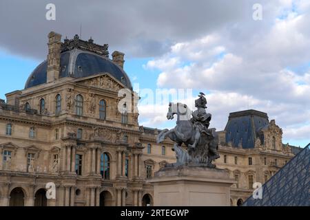 Statue und Gebäude im Louvre-Museum in Paris; Paris, Frankreich Stockfoto