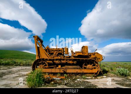 Große Planierraupe in der Nähe eines Feldes; Umnak Island, Aleutian Islands, Alaska, Vereinigte Staaten von Amerika Stockfoto