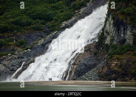 Touristen an den Nugget Creek Falls, die in den Mendenhall Lake münden; Juneau, Alaska, Vereinigte Staaten von Amerika Stockfoto