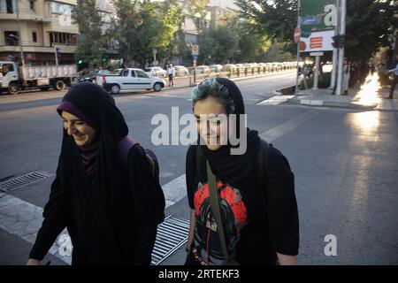 Teheran, Iran. September 2023. Zwei junge iranische Frauen spazieren entlang der Enghelab (Revolution) Straße in der Innenstadt von Teheran. Ein Jahr nachdem der Tod von Mahsa Amini Unruhen im ganzen Iran auslöste, bleibt das Thema Hijab ein schmerzhafter Ort. Doch eine verkrüppelte Wirtschaftskrise hat viele mit dem Ende beschäftigt. (Bild: © Rouzbeh Fouladi/ZUMA Press Wire) NUR REDAKTIONELLE VERWENDUNG! Nicht für kommerzielle ZWECKE! Stockfoto