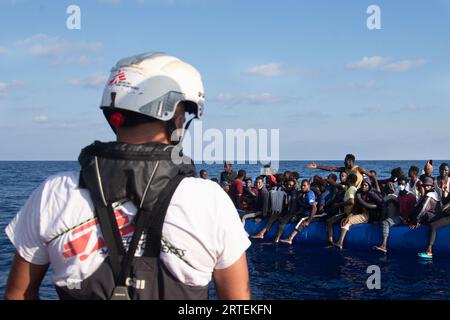 Libyen. Aug. 2023. Eines der Mitglieder des MSF-Rettungsteams tauscht sich mit einer Gruppe von 55 Migranten südlich der Sahara 27 Meilen von Libyen entfernt aus, bevor sie gerettet werden. Doctors Without Borders führt seine erste Rettung von 55 Menschen im Rotation 36 im Mittelmeer durch. (Bild: © Ximena Borrazas/SOPA Images via ZUMA Press Wire) NUR REDAKTIONELLE VERWENDUNG! Nicht für kommerzielle ZWECKE! Stockfoto