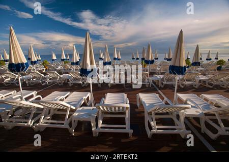 Strand mit Stühlen und Sonnenschirmen in Blau und weiß in Nizza, Frankreich; Nizza, Französische Riviera, Frankreich Stockfoto