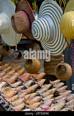 Sonnenhüte und Muschelmuscheln zum Verkauf in Tobago; Milford Bay, Tobago, Republik Trinidad und Tobago Stockfoto