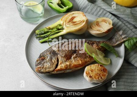 Köstlicher dorado-Fisch mit Gemüse auf hellgrauem Tisch Stockfoto