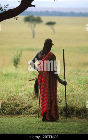 Masai-Krieger mit einem Speer, der über das Grasland im Masai Mara National Reserve, Kenia, blickt Stockfoto