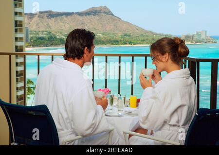 Hawaii, Oahu, Waikiki, Paare Genießen Frühstück Auf Ihrem Hotel Lanai, Diamond Head Hintergrund. Stockfoto