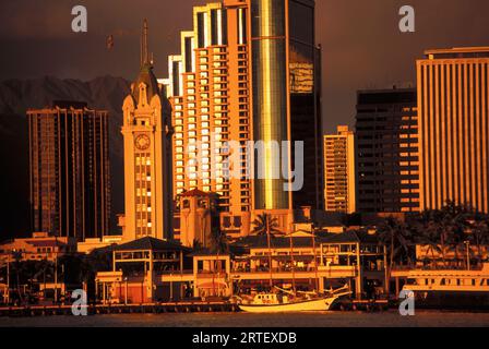 Hawaii, Oahu, Aloha Tower, Honolulu Harbor und Downtown Cast in A Golden Hue Stockfoto