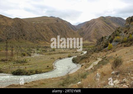 Gebirgsfluss umgeben von den Bergen im Kaukasus, bewölkter Himmel mit Textabstand Stockfoto