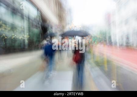 Verschwommenes Bild von Menschen, die auf der Stadtstraße laufen Stockfoto