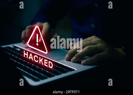 Mann, der einen Computer mit einem System verwendet, das gehackt wurde Warnschilder greifen auf das Computernetzwerk an. Datenschutz. Internet-Malware Cybersicherheit und Cyber Stockfoto