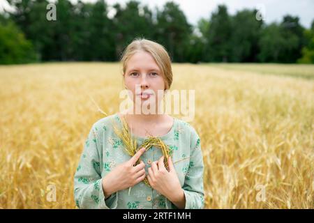 Porträt einer jungen Frau mit kleinem Kranz im Weizenfeld Stockfoto