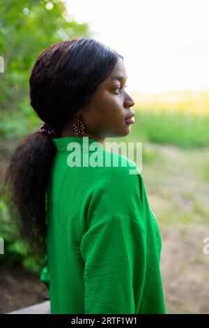 Seitenansicht einer brünetten Frau mit grüner Bluse Stockfoto