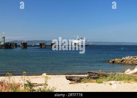 Eine Staatsfähre von Washington fährt vom Dock am Ufer von Edmonds ab und transportiert Autos, Lastwagen und Fußgänger über den Puget Sound Stockfoto