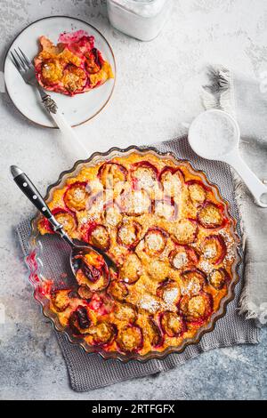 Flaugnarde oder Clafoutis: Französisches Dessert mit Pflaumen und großem Pfannkuchen, der im Ofen gebacken wird Stockfoto