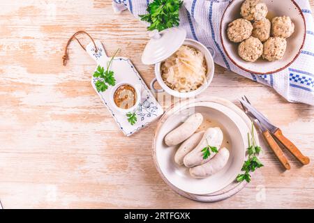 Bayerische Weißwürste mit Sauerkraut und Semmelknödeln, mit Senf. Stockfoto