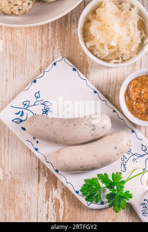 Bayerische Weißwürste mit Sauerkraut und Semmelknödeln, mit Senf. Stockfoto