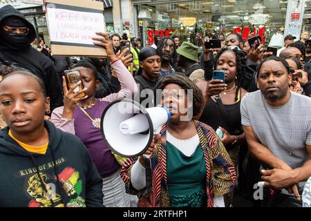 London, Großbritannien. September 2023. Ngozi Fulani (c} der Gründer einer Wohltätigkeitsorganisation für häuslichen Missbrauch spricht während der Demonstration auf Ryle Lane. Demonstratoren versammelten sich vor dem Peckham Hair and Cosmetics Shop über ein Video, das in den sozialen Medien zirkulierte. Das Video zeigt einen Streit zwischen einer Frau und dem männlichen Besitzer von Peckham Hair and Cosmetics, Sohail Sindho, 45, der während der Auseinandersetzung seine Hände um ihre Kehle zu legen scheint. Quelle: SOPA Images Limited/Alamy Live News Stockfoto