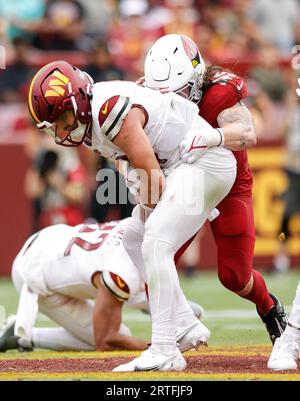 Washington Commanders QB Sam Howell (14) hält sich am Ball fest, als er von Cardinals OLB Dennis Gardeck (45) beim Spiel Arizona Cardinals vs Washington Commanders (Woche 1) am 10. September 2023 im FedEx Field in Landover, MD. (Alyssa Howell/Image of Sport) entlassen wird. Stockfoto