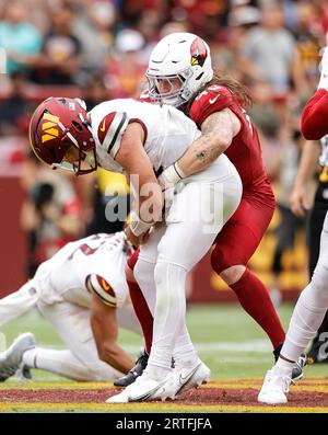 Washington Commanders QB Sam Howell (14) hält sich am Ball fest, als er von Cardinals OLB Dennis Gardeck (45) beim Spiel Arizona Cardinals vs Washington Commanders (Woche 1) am 10. September 2023 im FedEx Field in Landover, MD. (Alyssa Howell/Image of Sport) entlassen wird. Stockfoto
