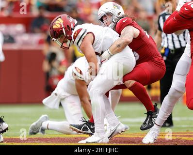 Washington Commanders QB Sam Howell (14) hält sich am Ball fest, als er von Cardinals OLB Dennis Gardeck (45) beim Spiel Arizona Cardinals vs Washington Commanders (Woche 1) am 10. September 2023 im FedEx Field in Landover, MD. (Alyssa Howell/Image of Sport) entlassen wird. Stockfoto