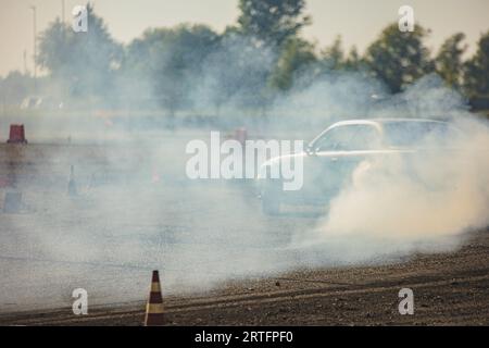 Ein Rennen mit einer hohen Oktanzahl von Autos, das im rauschenden Rauschen gefangen ist und Geschwindigkeit und Können zeigt. Stockfoto