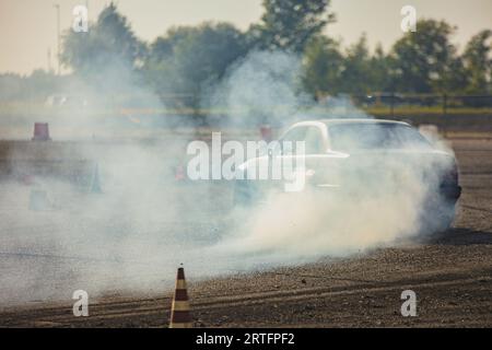 Ein Rennen mit einer hohen Oktanzahl von Autos, das im rauschenden Rauschen gefangen ist und Geschwindigkeit und Können zeigt. Stockfoto