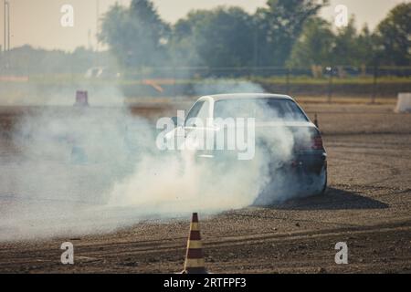 Ein Rennen mit einer hohen Oktanzahl von Autos, das im rauschenden Rauschen gefangen ist und Geschwindigkeit und Können zeigt. Stockfoto