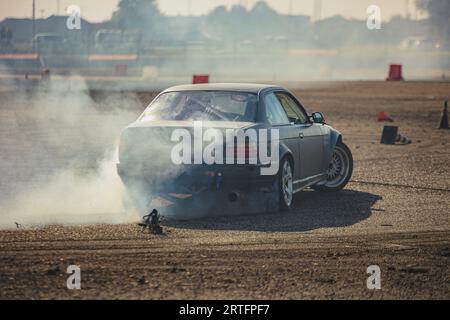 Ein Rennen mit einer hohen Oktanzahl von Autos, das im rauschenden Rauschen gefangen ist und Geschwindigkeit und Können zeigt. Stockfoto