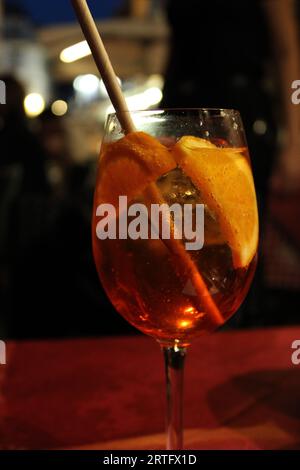 Eine leuchtend orangefarbene Zitrusgarnitur auf einem erfrischenden Cocktailglas auf einem Restauranttisch Stockfoto