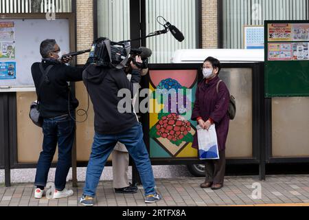 Nagasaki, Japan. März 2023. Ein Nachrichtenteam des NHK führt ein Interview an einer Straßenbahnstation der Nagasaki Electric Railway. Lokaljournalismus, Fernsehnachrichten, japanisches Fernsehen. (Bild: © Taidgh Barron/ZUMA Press Wire) NUR REDAKTIONELLE VERWENDUNG! Nicht für kommerzielle ZWECKE! Stockfoto