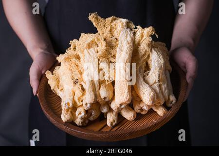 Getrockneter tropischer Stinkhornpilz, Phallus indusiatus, getrockneter Bambuspilz in Teller für den Einsatz in heißen Töpfen Stockfoto